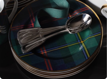 Stack of plaid dinner plates and silverware.