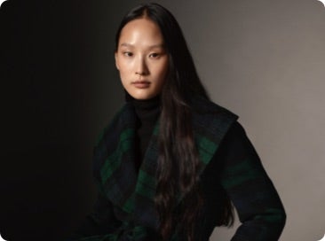 Woman wears green plaid coat.