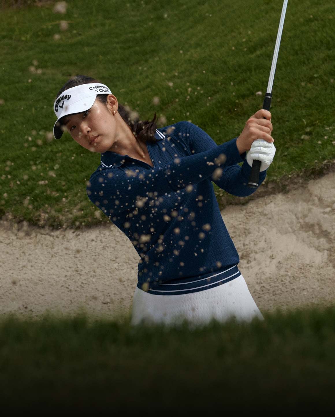 Andrea Lee on golf course wears light green Polo and pleated skirt.