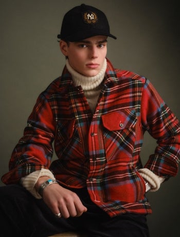 Man wars navy coat over red plaid blazer.