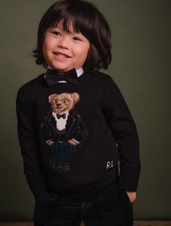 Boy wears green plaid quarter-zip and jeans.
