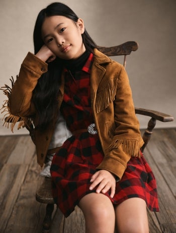 Girl wears plaid dress with peter pan collar.