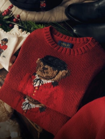 Red sweater with knit Polo Bear family at front hanging on hanger.